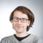 Henkilökuvassa mies katsoo kameraan, silmälasit ja ruskeat hiukset.