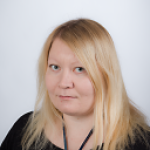 Vaaleahiuksinen nainen katsoo kameraan.