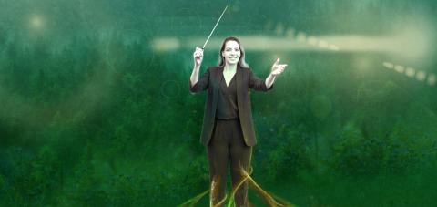 A figure conducts music in a green forest-like setting, with the figure’s legs transforming into branching roots extending into the ground.