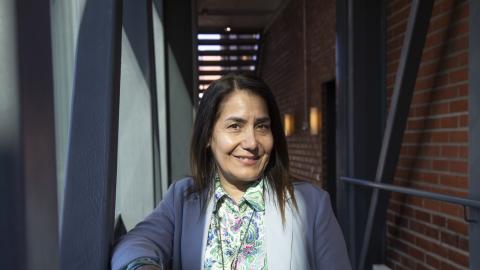 Henkilö hymyilee palkkien välissä.