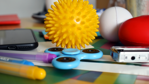 Oppimispulmissa käytettäviä välineitä: spinneri, kumipalloja, tusseja.