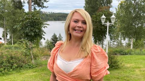 Yksi henkilö seisoo pihalla. Taustalla järvimaisema.