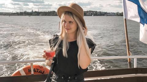 Victoria Laaksonen on a boat with Finnish flag next to her
