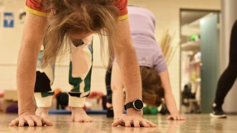 Two people in yoga poses in the gym.