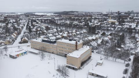 Nekalan vanha koulurakennus kuvattuna ilmasta talvisena päivänä.