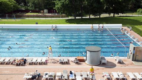 People in the sunny outdoor swimming pool.