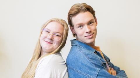 Venla ja Oliver sit side by side and smile to the camera.