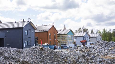 Rakenteilla olevia omakotitaloja rivistö ja ympärillä sorakasoja.
