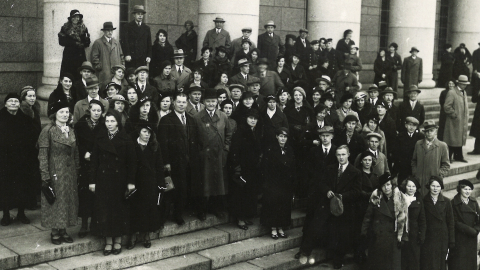 Suuri joukko ihmisiä seisoo eduskuntatalon portailla.