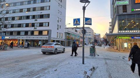 Jalankulkijoita ja auto Puutarhakadun ja Kuninkaankadun risteyksessä.