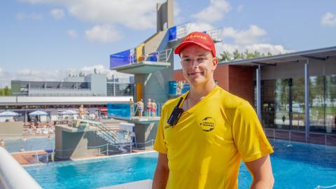 Kuvassa maauimalan uimavalvoja Karri-Kasperi Lehminiemi poseeraa altaan edessä.