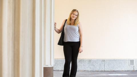 A woman leaning on the pillar on left to her.