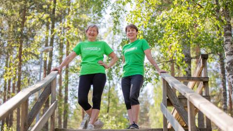 Iloisia naisia portailla metsän keskellä.