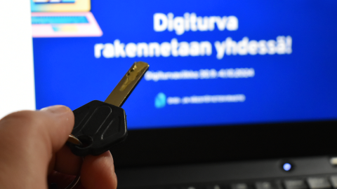 The theme page for Digital Security Week on a computer. In the foreground, there is a key.