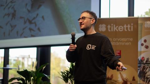 Shein Shapiro seisoo esiintymislavalla mikrofoni kädessään.