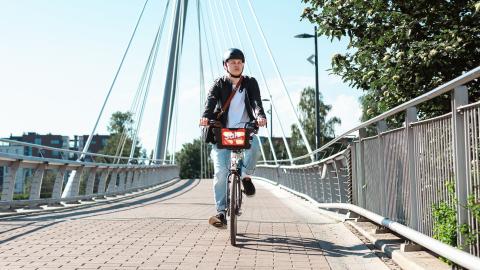 Mies ajaa kaupunkipyörällä Laukonsillalla Tampereella.