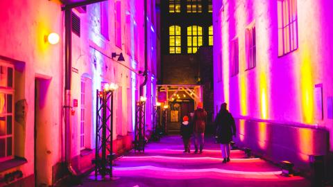 The narrow alley in the Finlayson area is impressively illuminated with purple and orange lights.