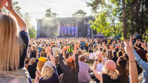 Festivaaliyleisöä etualalla, lava taka-alalla