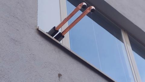 Kuva ilmanlaadun mittausputkista koulun seinässä.