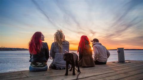 Nuoria istumassa laiturilla Lapinniemessä