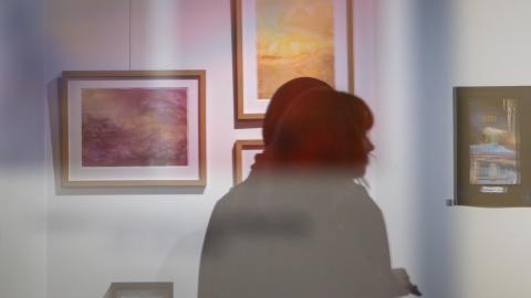 Kaksi henkilöä katsomassa taidenäyttelyä