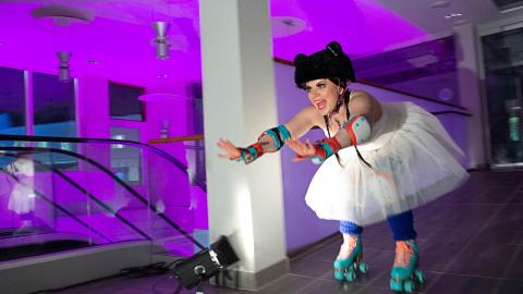 Nainen luistelee rullaluistimilla yhdessä kulttuurin välitiloista.