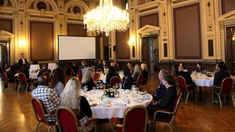 People seated at lunch tables inside Tampere City Hall.