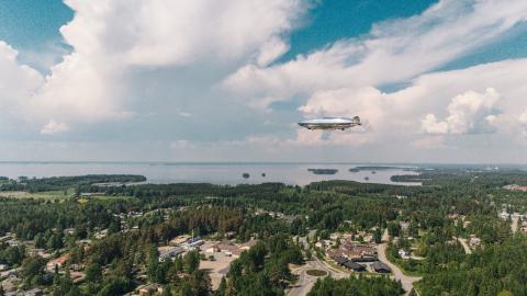 Ilmalaiva kelluu Joensuun keskustan yllä.