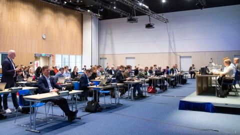 Kaupunginvaltuutetut istuvat pulpeteissaan isossa salissa ja heidän edessään istuu puheenjohtaja.