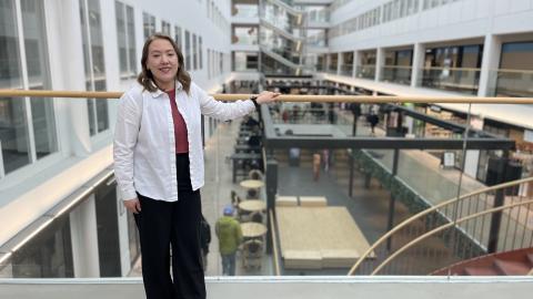 Henkilö katsoo kohti kameraa ja nojaa kaiteeseen Tullintorin kauppakeskuksessa.