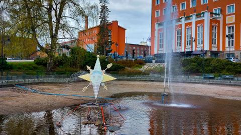 Tyhjä lampi, jossa on tähdenmuotoinen värikäs teos ja suihkulähde.