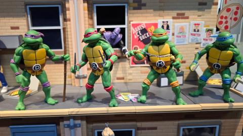 Lelu Turtles-hahmoja rivissä pienoismallitalon parvella.