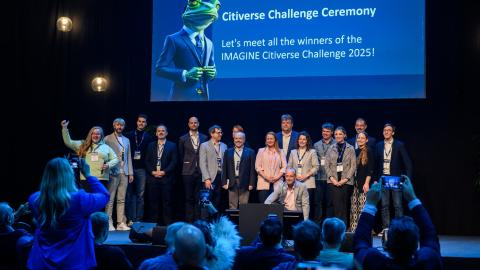 Ihmisiä seisoo tapahtumalavalla iloisen näköisinä. 