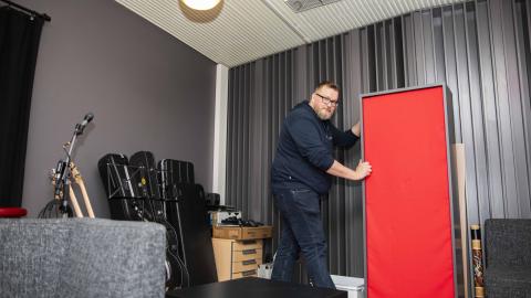 Teemu Haapakoski looks into the camera and moves basstrap in the studio of Monitoimitalo 13.