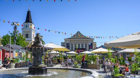 A summer market with covered terrace tables in the central square of Tampere.