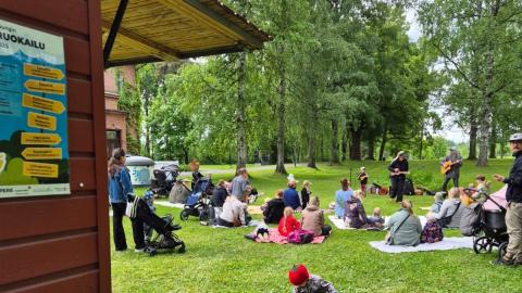 People sitting on the lawn with food.