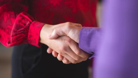 Kaksi henkilöä kättelee.