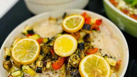 Vegetable-based food served topped with lemon slices.