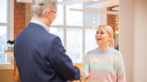 Nuori henkilö kättelee vanhempaa henkilöä.