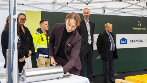 Ilmari Nurminen puts an object into a time capsule during the ceremony.