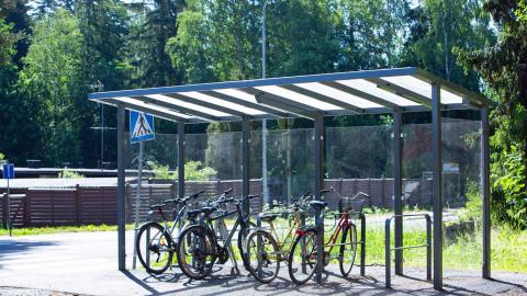 Pyöriä pyörätelineissä katoksen alla kesäaikaan.