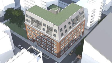 Kuvassa punatiilinen rakennus ja korotuskerros ilmakuvaperspektiivistä.