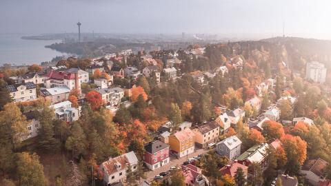 Syksyinen maisema, jossa on runsaasti taloja. Taustalla on järvi.