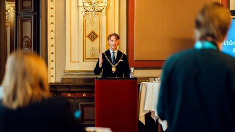 Puhujakorokkeen takana seisova pormestari Ilmari Nurminen kertoo Raatihuoneella vuoden 2026 talousarvioehdotuksesta medialle 22.10.2025.