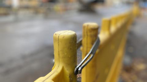 Keltaista katutyömaa-aitaa työmaan reunalla.