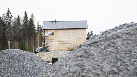 Sorakasan takaa näkyy keskeneräisen omakotitalon rakennustyömaa metsikön laidalla.