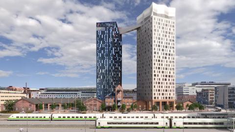 The picture shows the station, trains, and two tower-like buildings.