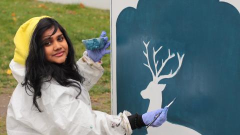 Nuori nainen maalaa sähkökaappia Etelä-Hervannassa.