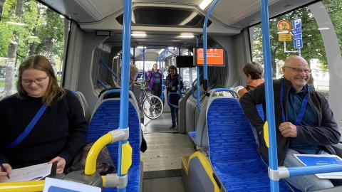 Asiakkaat testaavat superbussia ja täyttävät lomakkeita.