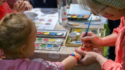 Ikäihminen maalaa lapsen kanssa